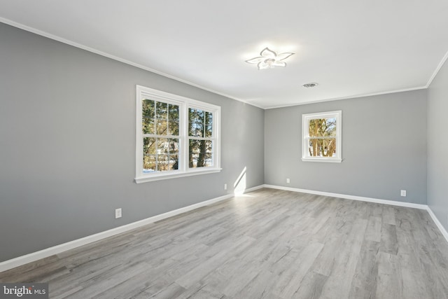 unfurnished room with light hardwood / wood-style floors, plenty of natural light, and ornamental molding