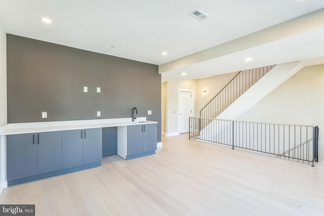 kitchen featuring kitchen peninsula, sink, and light hardwood / wood-style floors