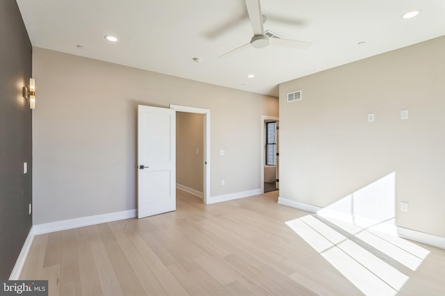 empty room with ceiling fan and light hardwood / wood-style floors