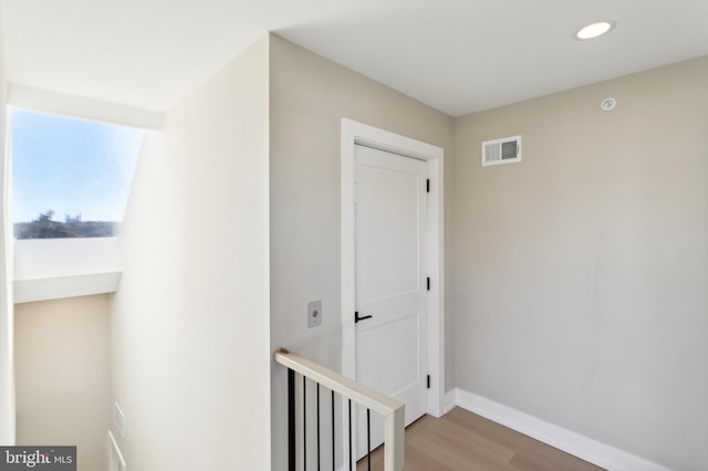 hallway with hardwood / wood-style floors