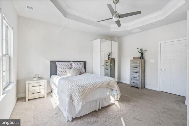 bedroom with ceiling fan and a raised ceiling