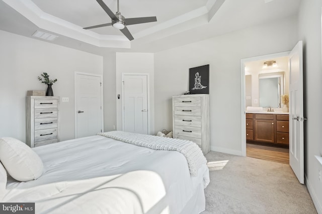 carpeted bedroom featuring sink, ceiling fan, ensuite bathroom, and a raised ceiling