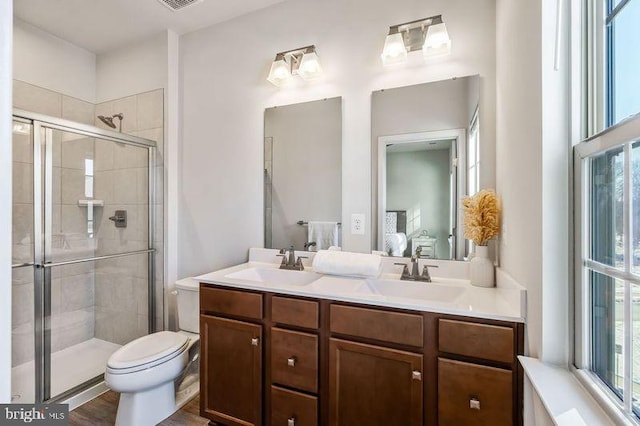 bathroom featuring vanity, toilet, an enclosed shower, and wood-type flooring