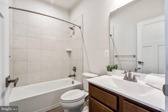 full bathroom featuring tiled shower / bath combo, vanity, and toilet