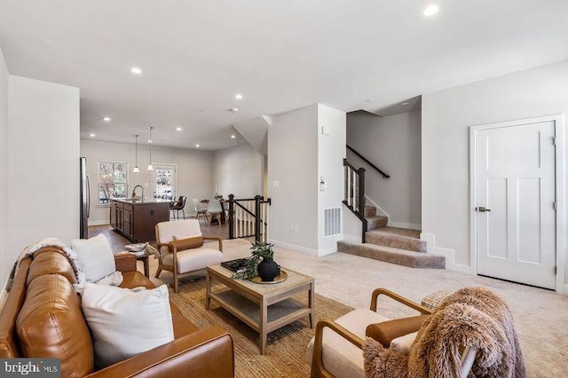 living room with sink and light colored carpet