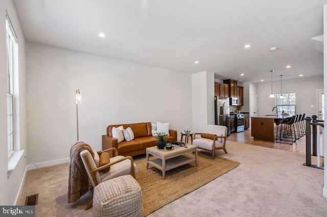 carpeted living room with sink