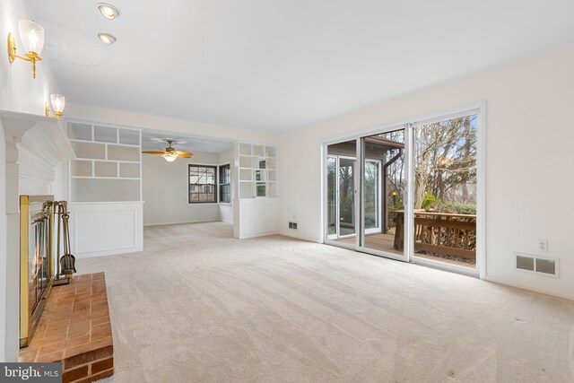 unfurnished living room featuring a healthy amount of sunlight, carpet, and visible vents