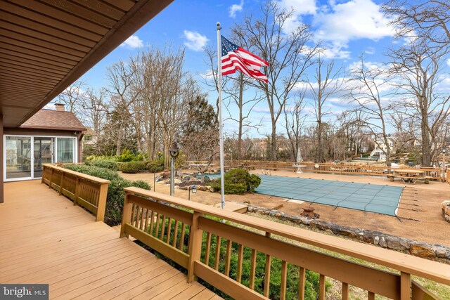 wooden terrace with a patio area and a covered pool