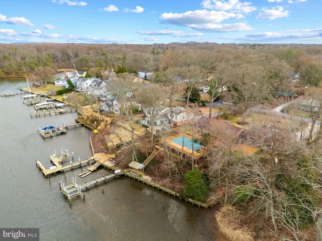 birds eye view of property featuring a water view and a view of trees