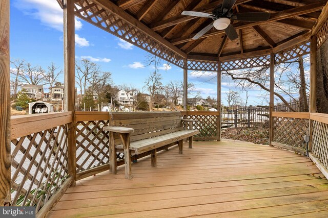 wooden terrace featuring a gazebo, a residential view, and a ceiling fan