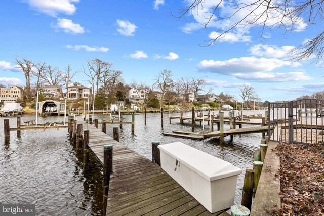 dock area with a residential view, a water view, and boat lift