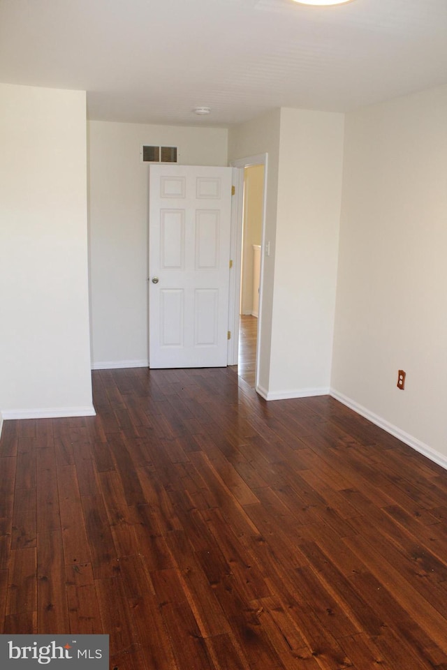 spare room with dark hardwood / wood-style flooring