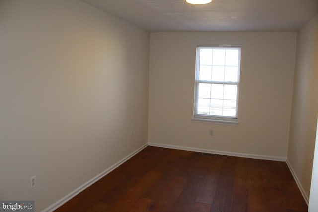 spare room with dark hardwood / wood-style floors