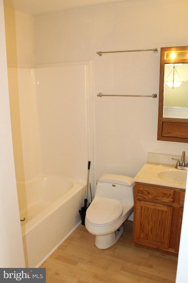 full bathroom featuring toilet, vanity, bathing tub / shower combination, and hardwood / wood-style flooring