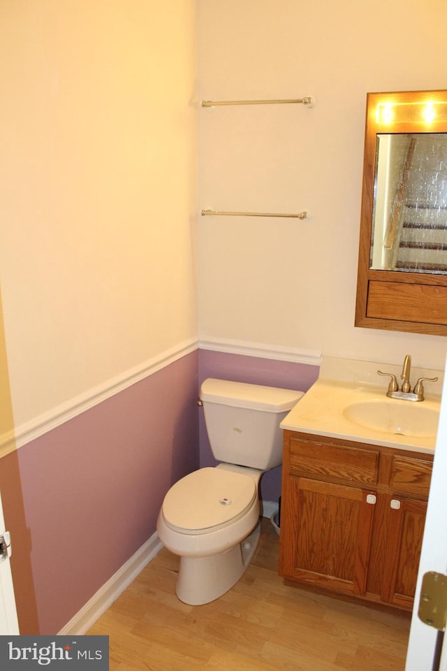 bathroom featuring toilet, hardwood / wood-style floors, and vanity