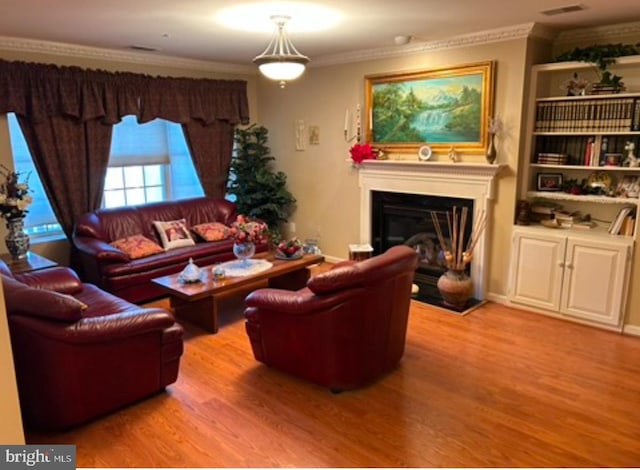 living room featuring crown molding and light hardwood / wood-style flooring