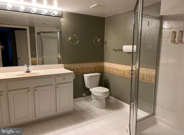 bathroom featuring tile patterned flooring, vanity, toilet, and walk in shower