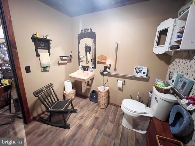 bathroom with hardwood / wood-style flooring and toilet