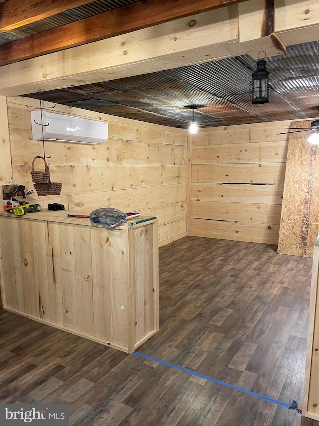 basement featuring an AC wall unit, dark wood-type flooring, and wooden walls