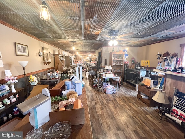 miscellaneous room with ceiling fan, wood walls, and hardwood / wood-style floors