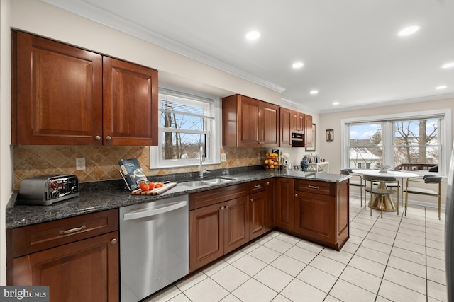 kitchen with crown molding, stainless steel dishwasher, dark stone countertops, and sink