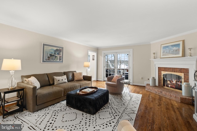 living room with a brick fireplace, crown molding, and hardwood / wood-style floors