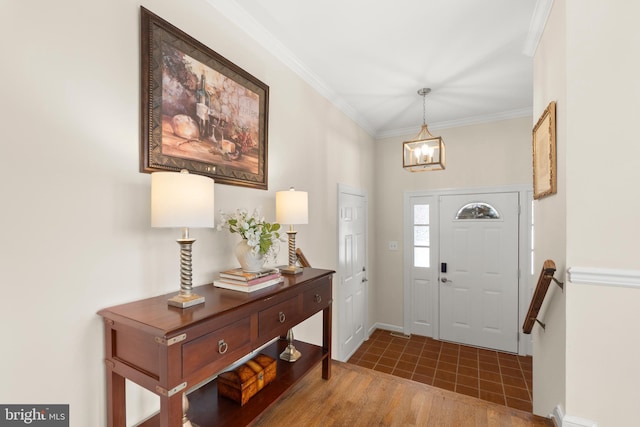 foyer entrance with ornamental molding and hardwood / wood-style flooring