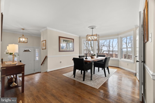 dining space featuring dark wood-type flooring, crown molding, and a chandelier