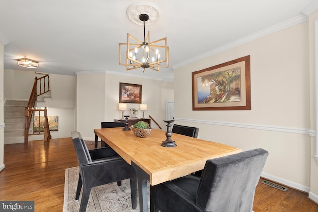 dining area featuring a notable chandelier, crown molding, and hardwood / wood-style floors