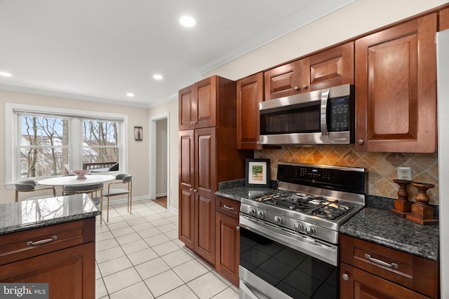 kitchen with decorative backsplash, appliances with stainless steel finishes, and dark stone countertops