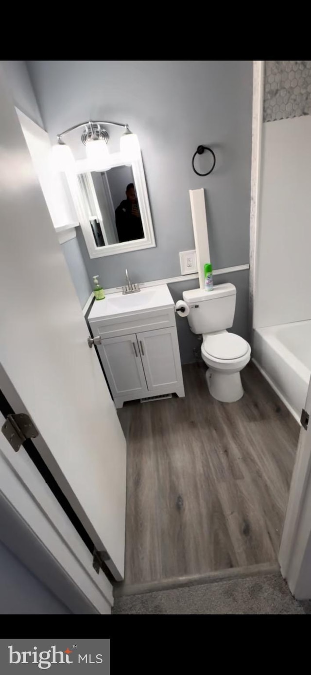 bathroom featuring toilet, vanity, and hardwood / wood-style floors