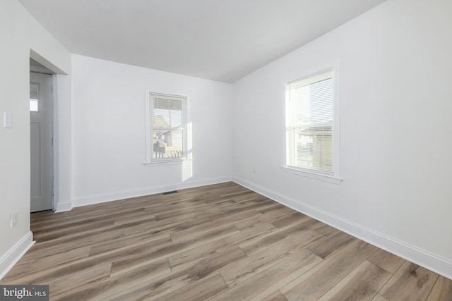 unfurnished room with a wealth of natural light and light hardwood / wood-style floors