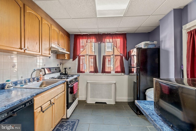 kitchen featuring black appliances, radiator heating unit, decorative backsplash, sink, and a drop ceiling