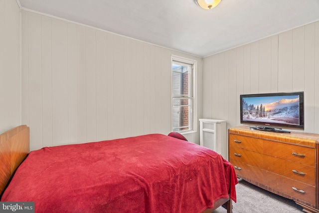 bedroom with carpet flooring and wood walls