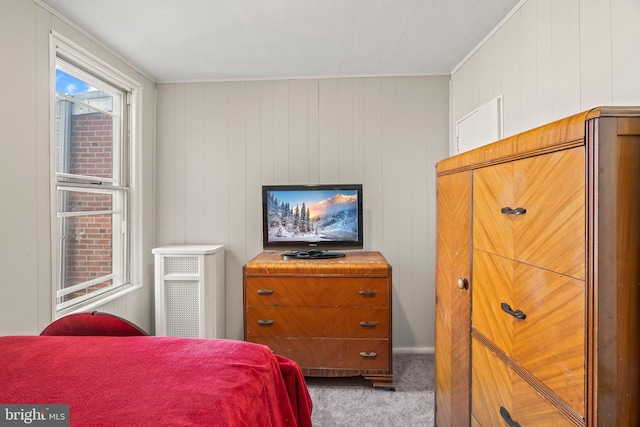 bedroom featuring wooden walls, radiator heating unit, and carpet flooring