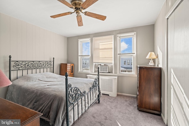 bedroom with ceiling fan, light colored carpet, a closet, and radiator heating unit