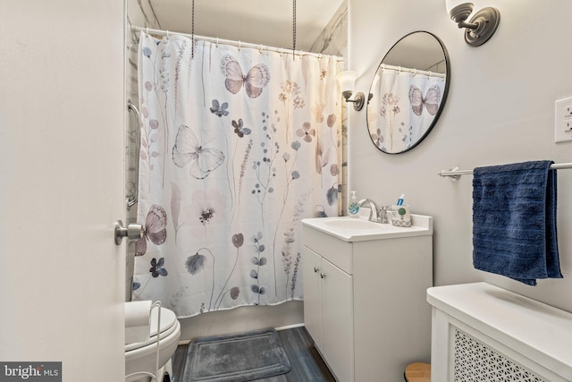 bathroom with toilet, wood-type flooring, vanity, and curtained shower