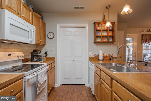 kitchen with tasteful backsplash, white appliances, dark hardwood / wood-style flooring, hanging light fixtures, and sink