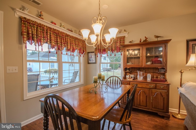 dining room with dark wood-type flooring and a notable chandelier