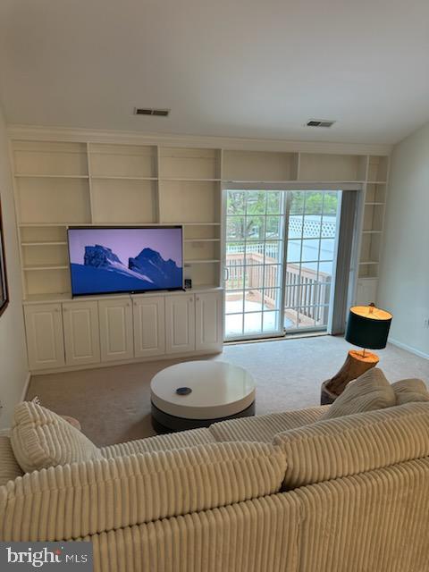 carpeted living room featuring built in features