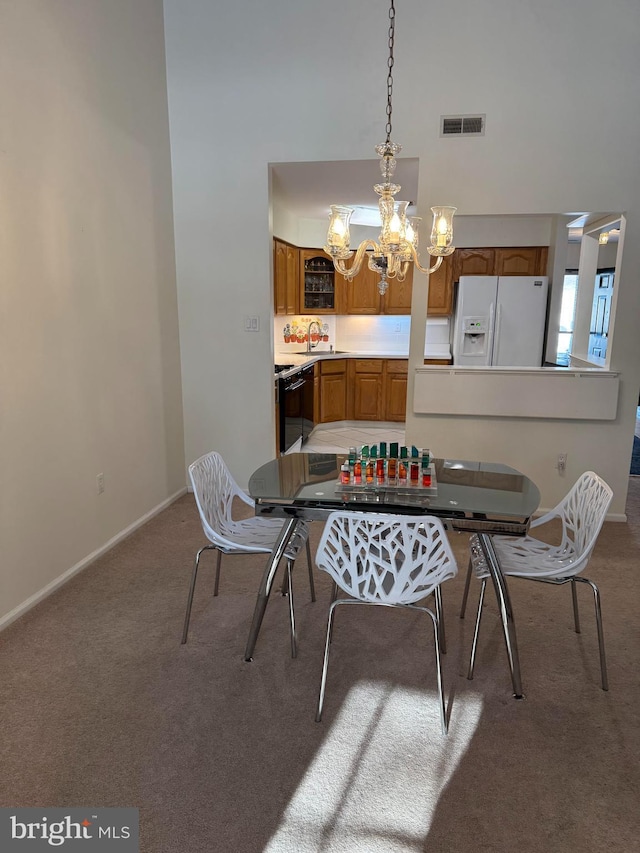 dining room featuring a high ceiling, carpet, and a notable chandelier