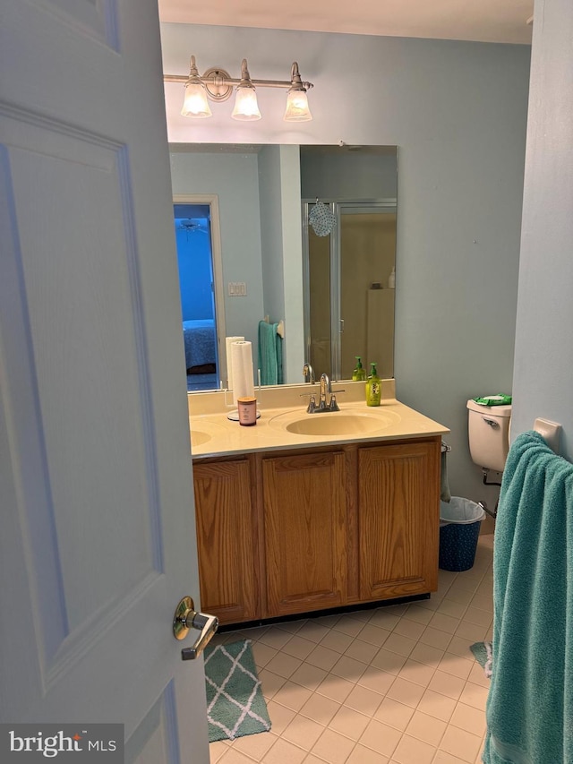 bathroom featuring walk in shower, vanity, tile patterned floors, and toilet