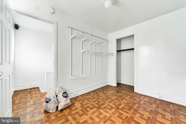 spacious closet featuring dark parquet flooring