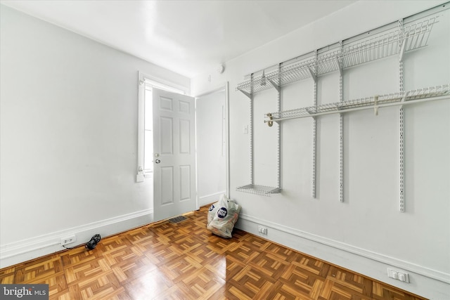 spacious closet with dark parquet floors