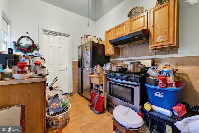 kitchen with decorative backsplash, appliances with stainless steel finishes, and light wood-type flooring