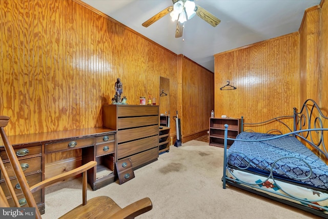 carpeted bedroom with ceiling fan and wooden walls