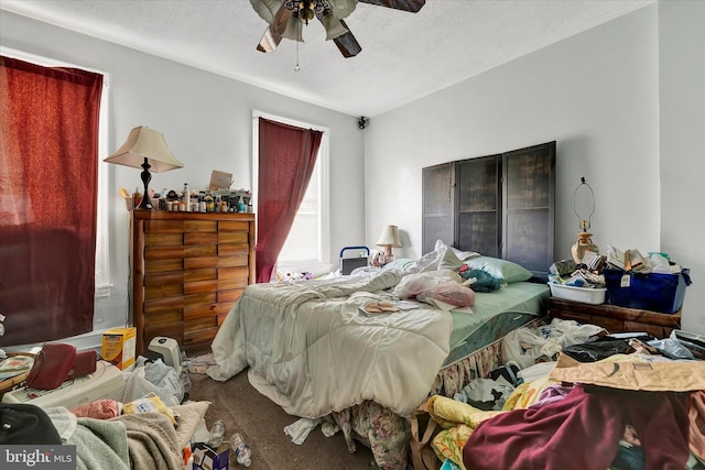 bedroom with a textured ceiling and ceiling fan