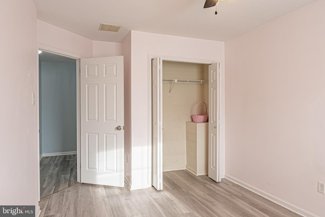 unfurnished bedroom featuring a closet, ceiling fan, and light wood-type flooring