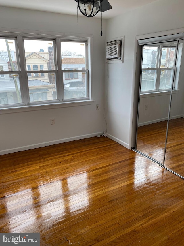 interior space featuring a wall mounted air conditioner, light hardwood / wood-style floors, and a closet