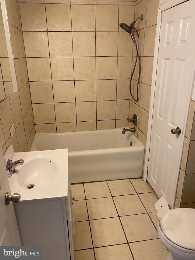 full bathroom with tile patterned flooring, vanity, tiled shower / bath combo, and toilet